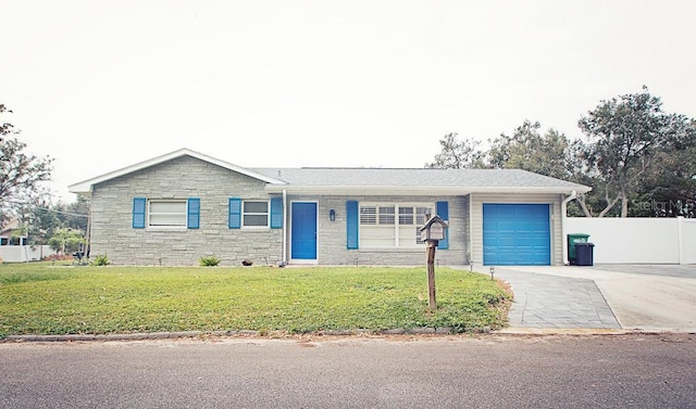 ranch-style house featuring an attached garage, fence, driveway, stone siding, and a front yard