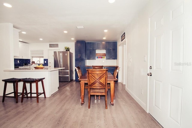 dining space featuring light wood-style floors, recessed lighting, and baseboards