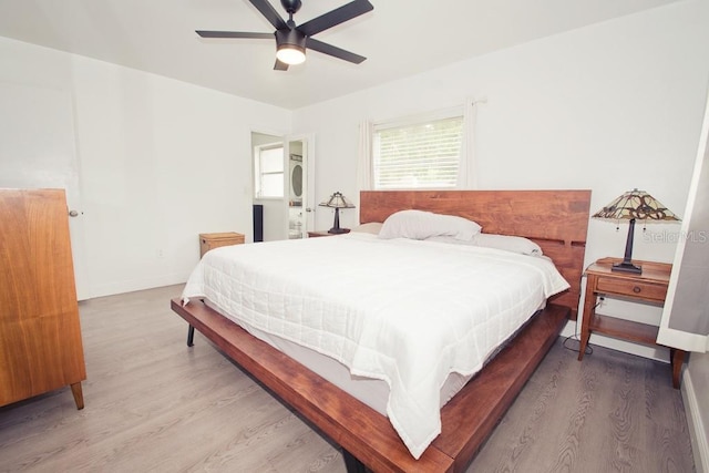 bedroom featuring light wood-style flooring, baseboards, and a ceiling fan