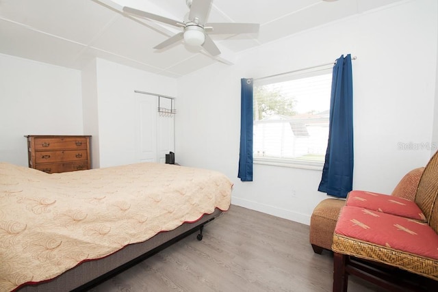 bedroom with ceiling fan, a closet, baseboards, and wood finished floors