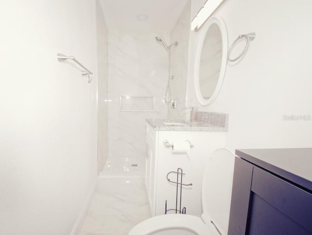 bathroom featuring marble finish floor, toilet, vanity, baseboards, and walk in shower