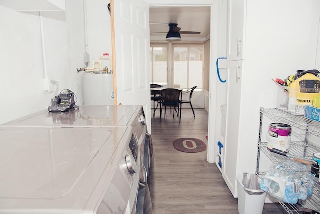 interior space featuring gas water heater, washer / clothes dryer, a ceiling fan, white cabinetry, and wood finished floors