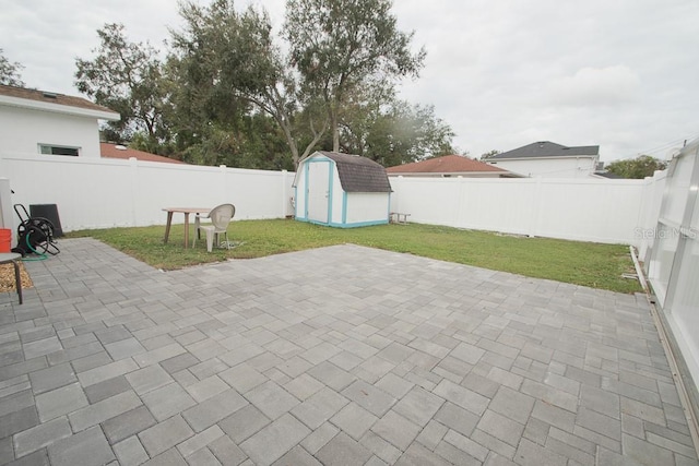 view of patio / terrace with a storage shed, an outdoor structure, and a fenced backyard