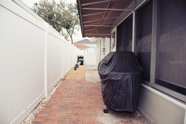 view of patio featuring fence, a carport, and area for grilling