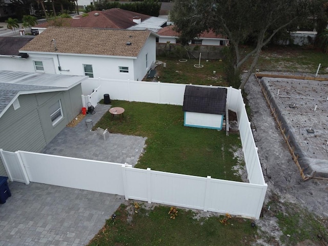 view of yard featuring a patio area, a fenced backyard, a shed, and an outdoor structure