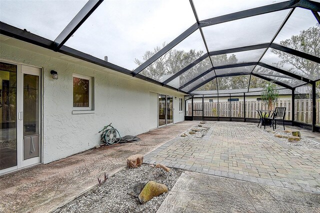 view of patio / terrace featuring a lanai and fence