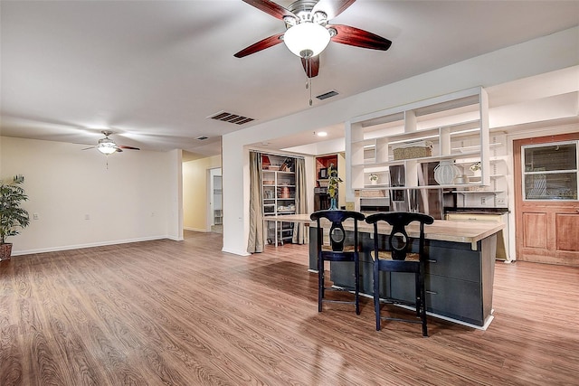 kitchen featuring ceiling fan, baseboards, visible vents, and light wood-style floors