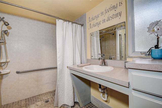 full bath with tiled shower and vanity