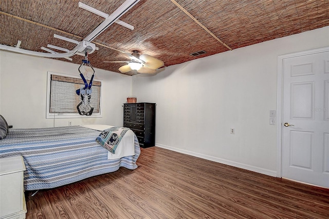 unfurnished bedroom featuring ceiling fan, wood finished floors, visible vents, and baseboards