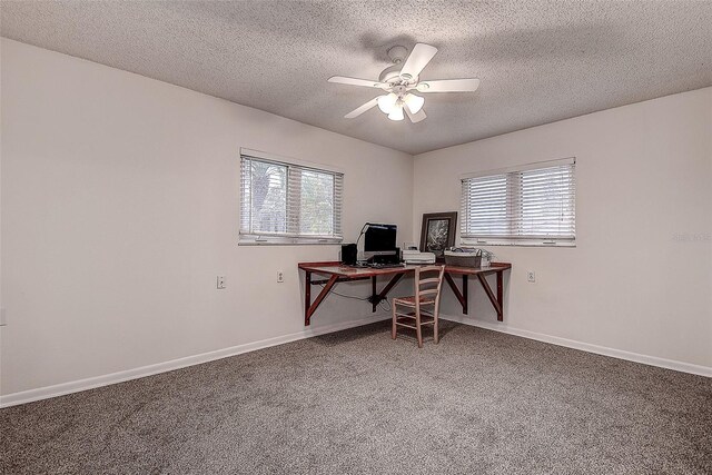 carpeted home office with ceiling fan, a textured ceiling, and baseboards