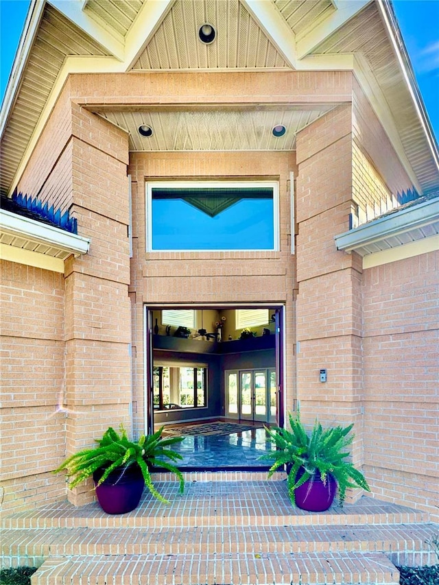 property entrance with brick siding and french doors