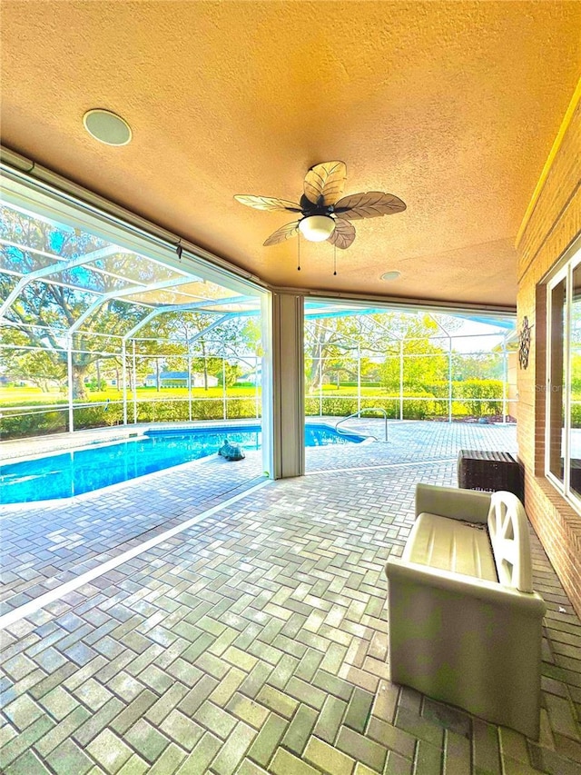 exterior space featuring a ceiling fan, a lanai, and an outdoor pool