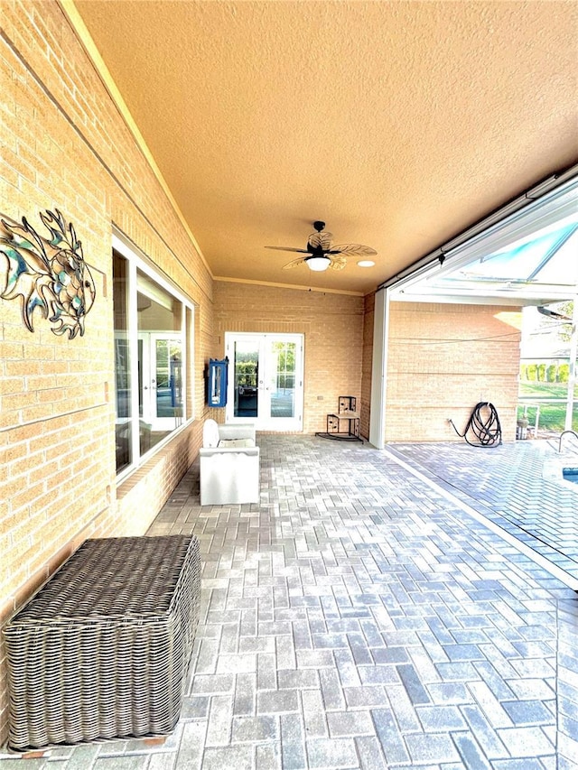 view of patio / terrace with french doors, glass enclosure, and ceiling fan