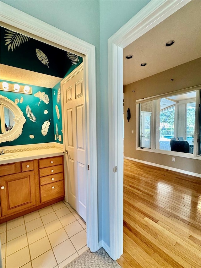 bathroom featuring recessed lighting, wood finished floors, vanity, and baseboards