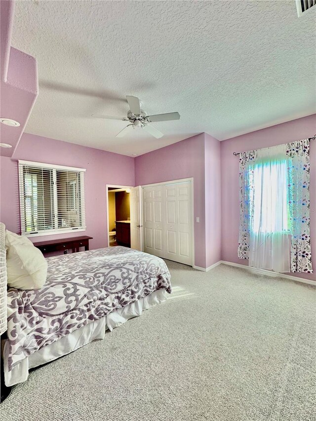 carpeted bedroom featuring visible vents, baseboards, ceiling fan, a textured ceiling, and a closet