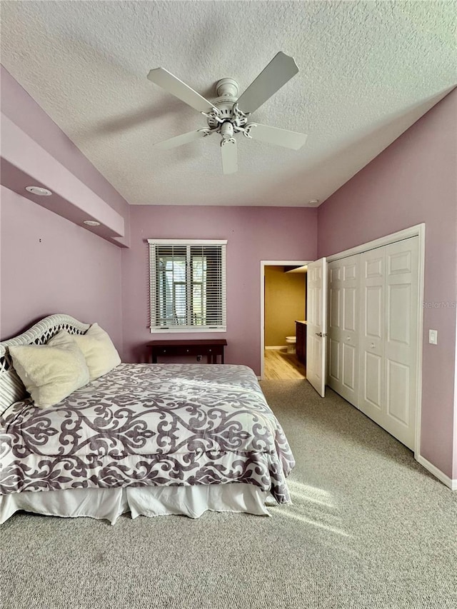 bedroom featuring a closet, light carpet, ceiling fan, and a textured ceiling