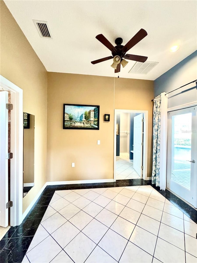 unfurnished room with baseboards, a ceiling fan, visible vents, and tile patterned floors