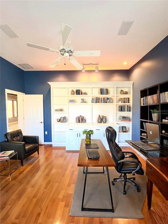 office featuring a ceiling fan, visible vents, and light wood-style flooring