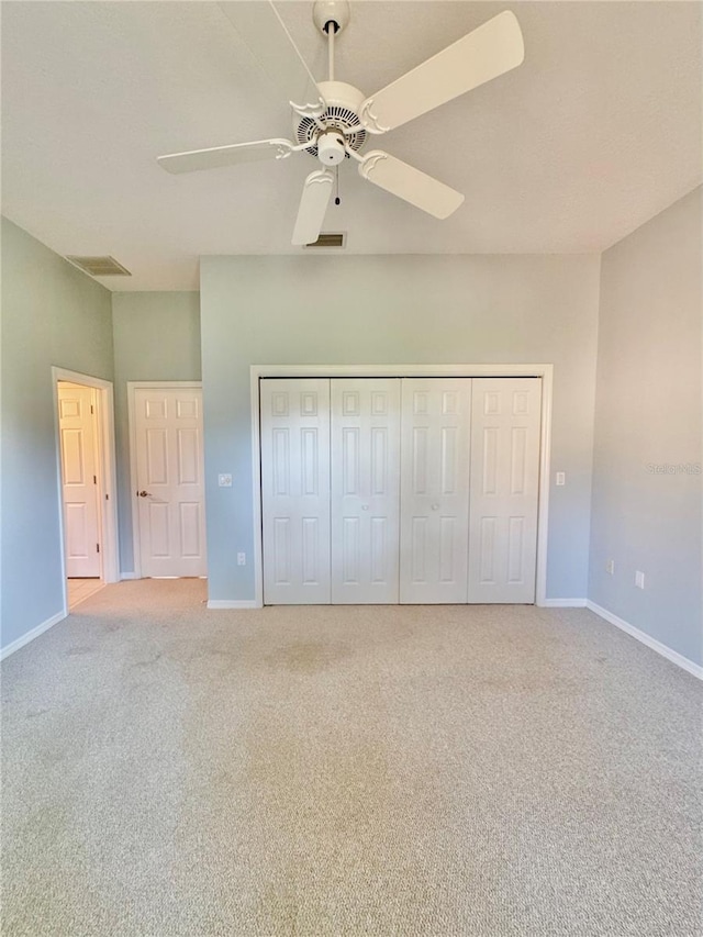 unfurnished bedroom with carpet floors, baseboards, visible vents, and a closet