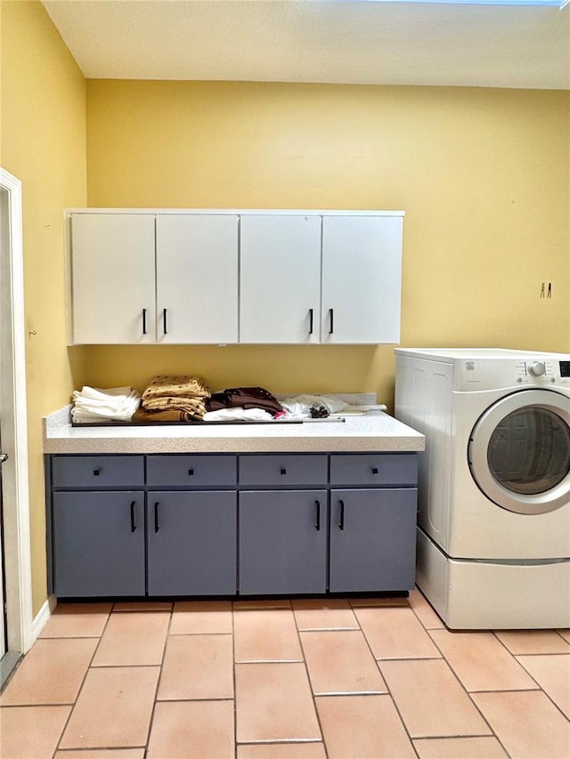 laundry room featuring washer / dryer, light tile patterned flooring, and cabinet space