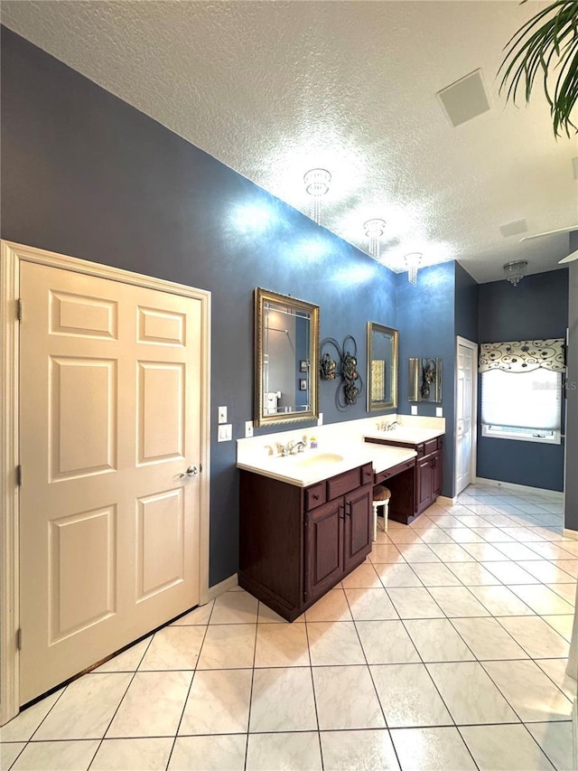 bathroom featuring tile patterned flooring, vanity, and a textured ceiling