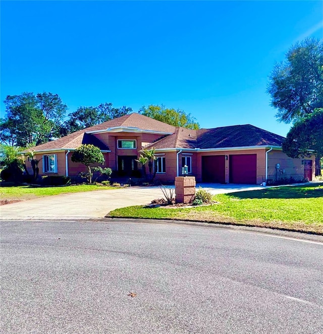 view of front of property featuring a garage, driveway, and a front yard