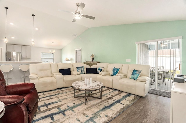 living room with ceiling fan, visible vents, vaulted ceiling, and wood finished floors