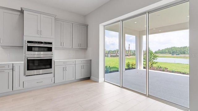 5646 Nevis Ter, Kissimmee, FL 34758 - kitchen with double oven, gray cabinets, light countertops, and light wood-type flooring