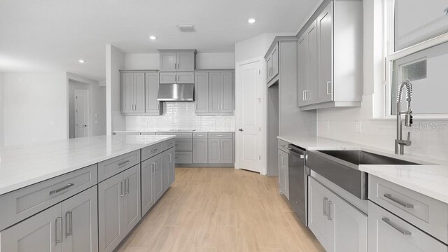 5646 Nevis Ter, Kissimmee, FL 34758 - kitchen featuring gray cabinetry, under cabinet range hood, a sink, dishwasher, and recessed lighting