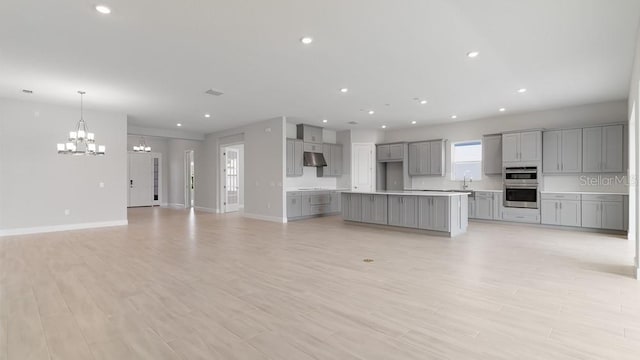 5646 Nevis Ter, Kissimmee, FL 34758 - unfurnished living room featuring a chandelier, baseboards, light wood finished floors, recessed lighting, and a sink
