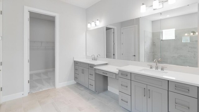 5646 Nevis Ter, Kissimmee, FL 34758 - bathroom with tiled shower, vanity, a spacious closet, and baseboards
