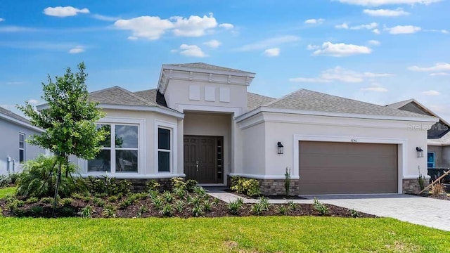 5646 Nevis Ter, Kissimmee, FL 34758 - view of front of house with stone siding, an attached garage, roof with shingles, decorative driveway, and stucco siding