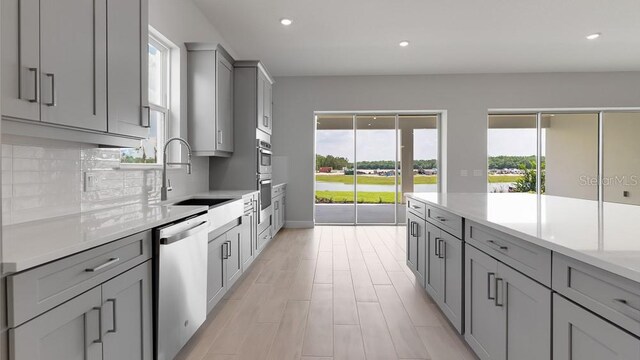5646 Nevis Ter, Kissimmee, FL 34758 - kitchen featuring gray cabinetry, stainless steel dishwasher, a sink, healthy amount of natural light, and recessed lighting