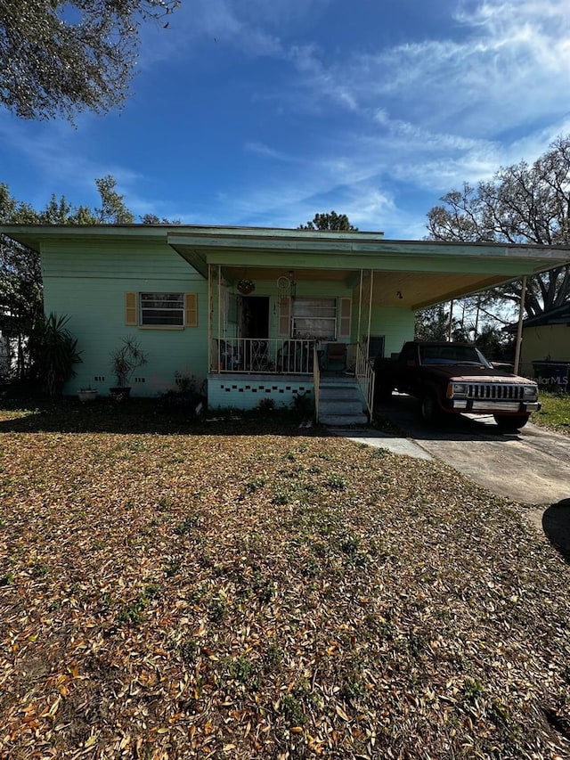 view of front of property featuring a porch, driveway, and a carport