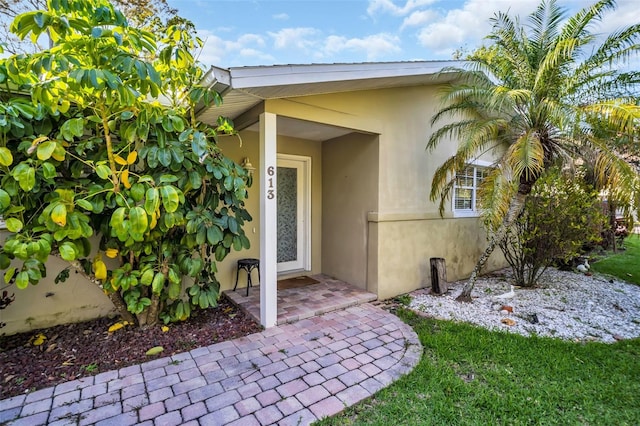 doorway to property featuring stucco siding