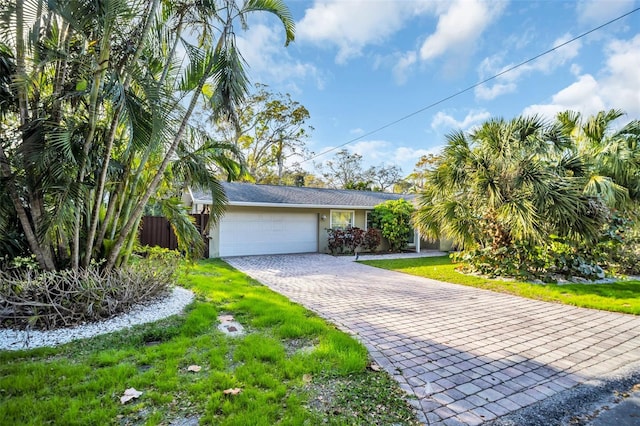 view of front facade with a garage, a front lawn, decorative driveway, and stucco siding