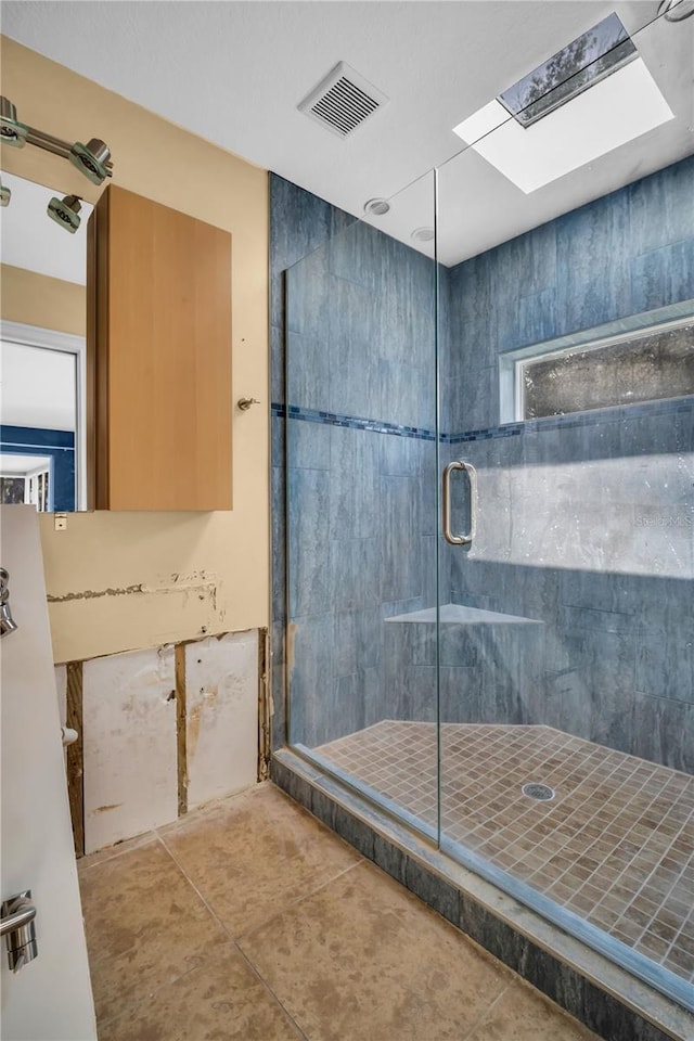 bathroom featuring a stall shower, a skylight, tile patterned flooring, and visible vents