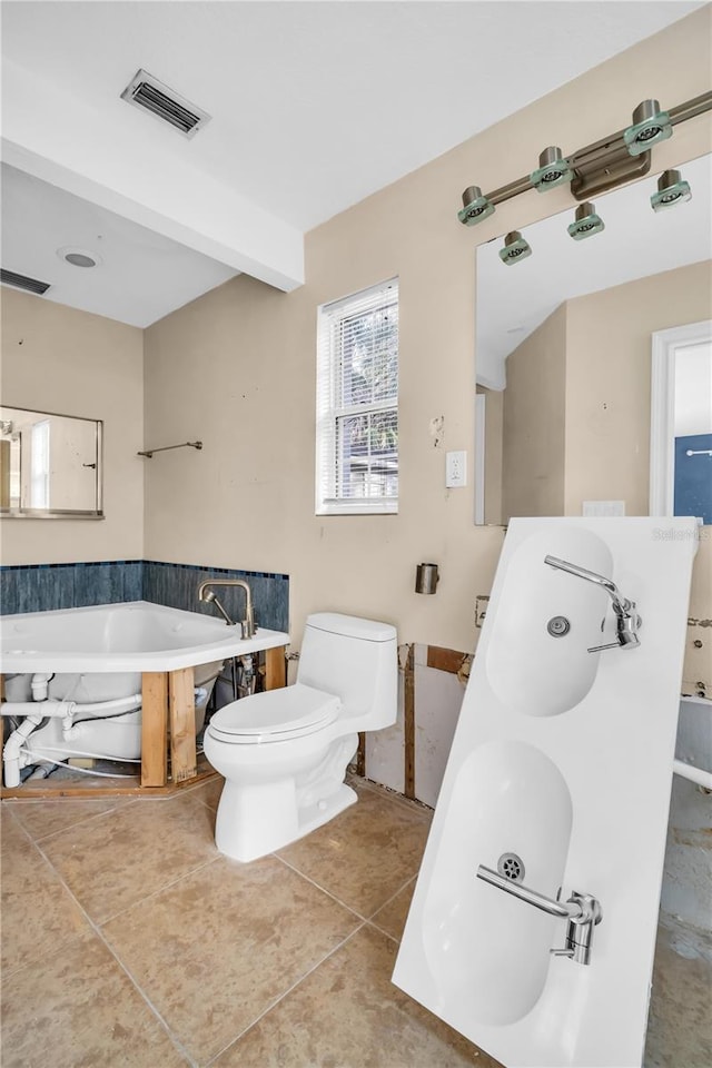 full bath featuring a garden tub, visible vents, toilet, a sink, and tile patterned flooring