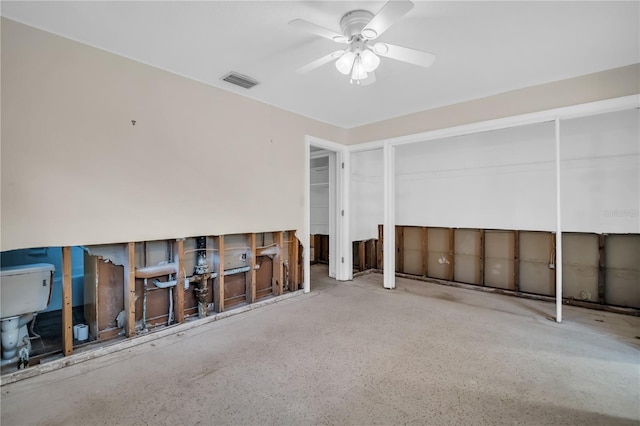 empty room featuring a ceiling fan, visible vents, and speckled floor