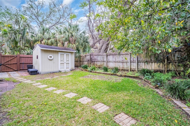 view of yard with a fenced backyard, an outbuilding, a gate, and a storage shed