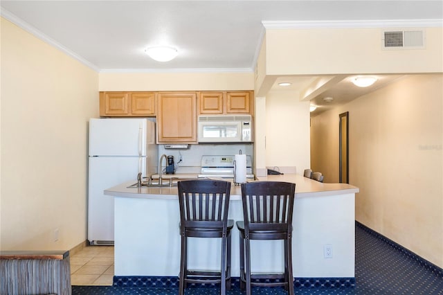 kitchen featuring white appliances, visible vents, a breakfast bar area, ornamental molding, and a peninsula