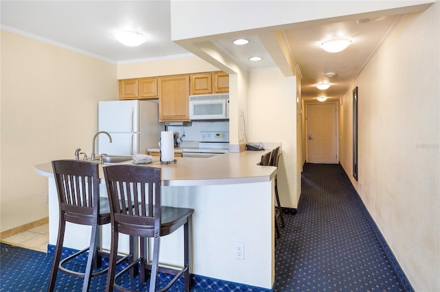 kitchen with crown molding, a breakfast bar area, light countertops, a sink, and white appliances