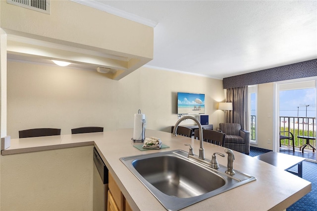 kitchen featuring crown molding, light countertops, visible vents, open floor plan, and a sink