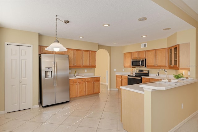 kitchen featuring appliances with stainless steel finishes, arched walkways, light countertops, and light tile patterned floors