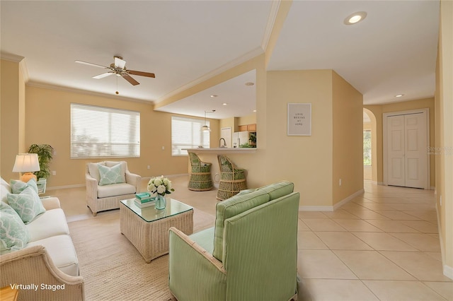 living room with light tile patterned floors, ornamental molding, and arched walkways