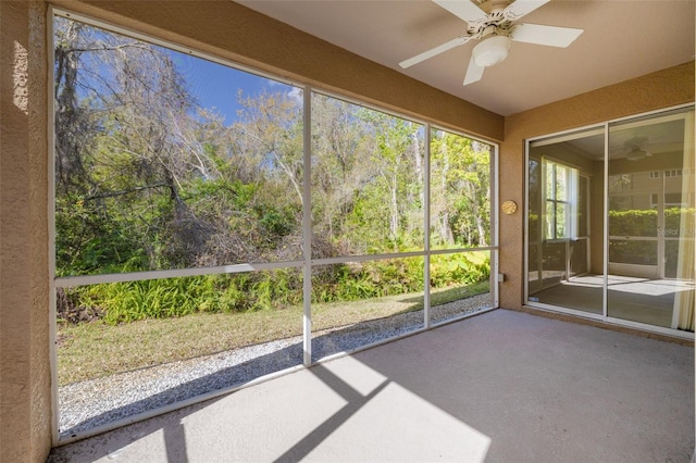 unfurnished sunroom with a ceiling fan