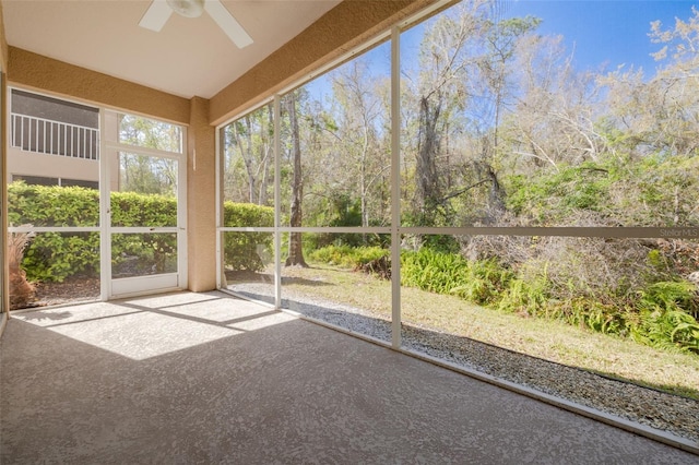 unfurnished sunroom with ceiling fan