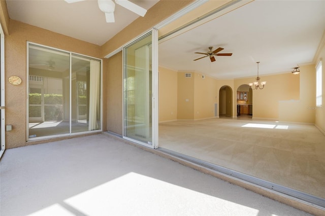 interior space featuring baseboards, arched walkways, crown molding, and ceiling fan with notable chandelier