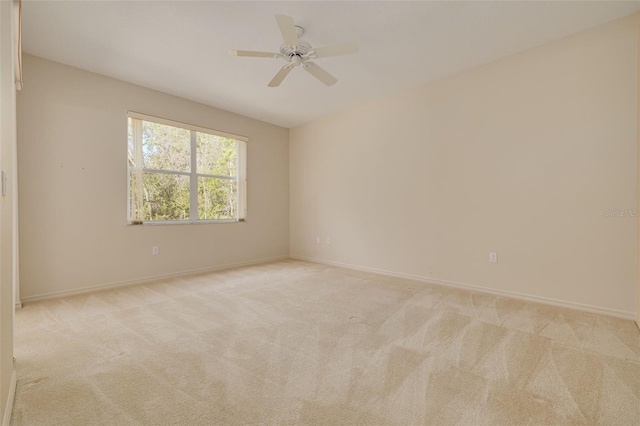 unfurnished room featuring light carpet, ceiling fan, and baseboards