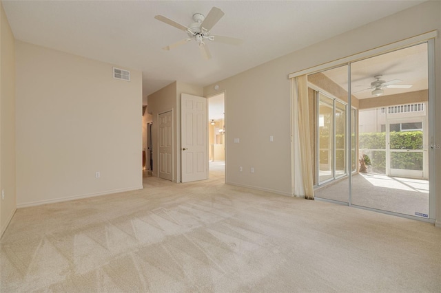 carpeted spare room featuring visible vents, ceiling fan, and baseboards